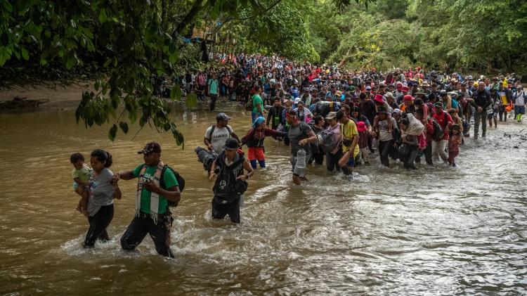 Centenas de migrantes cruzam rio na selva de Darién, ainda em território da Colômbia