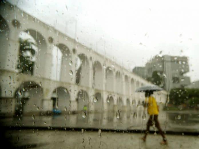 Mulher caminhando na Lapa usando guarda-chuva